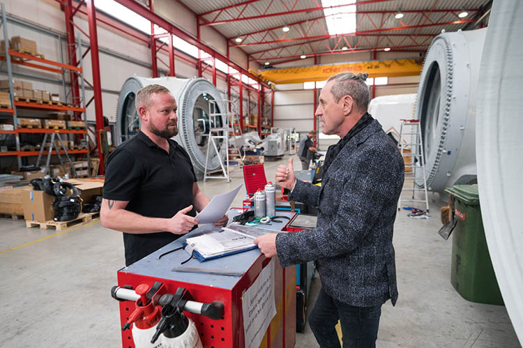 Zwei Männer unterhalten sich in der Produktionshalle von eno energy