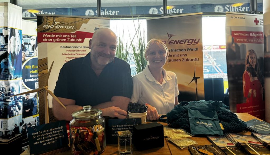Zwei Mitarbeiter von eno energy stehen hinter ihrem Stand auf der Jobmesse